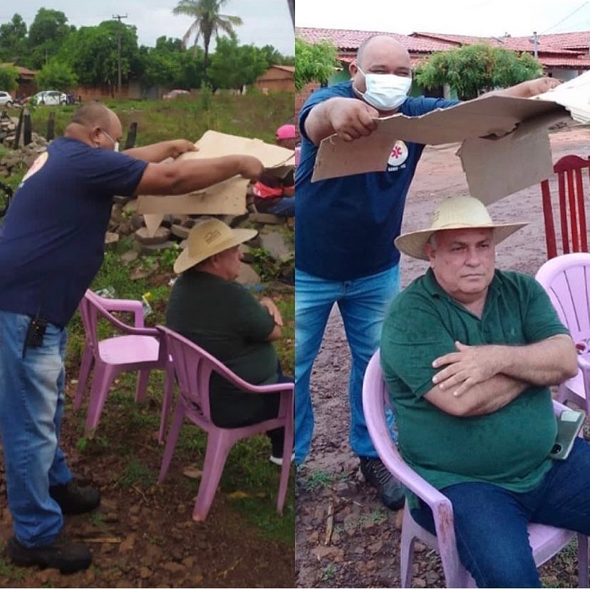 Funcionário de prefeitura segura papelão para prefeito do Maranhão não pegar chuvisco e foto viraliza